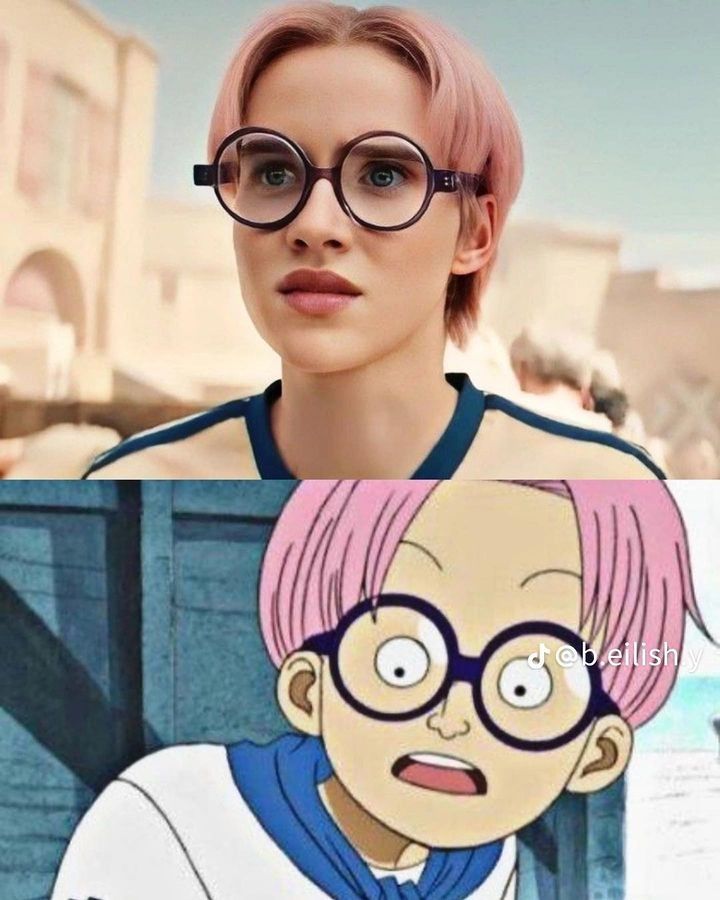 a woman with pink hair and glasses in front of a cartoon character that is looking at the