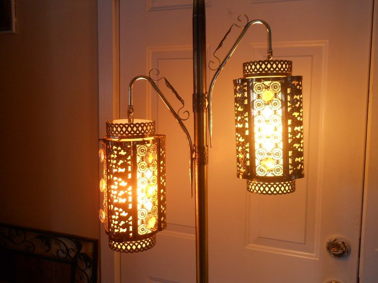 two lamps sitting next to each other in front of a door with lights on them