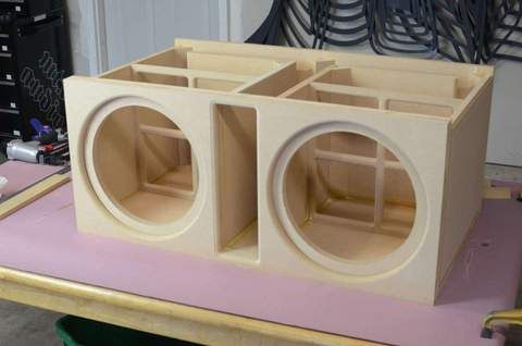 a couple of speakers sitting on top of a pink table next to a pair of scissors