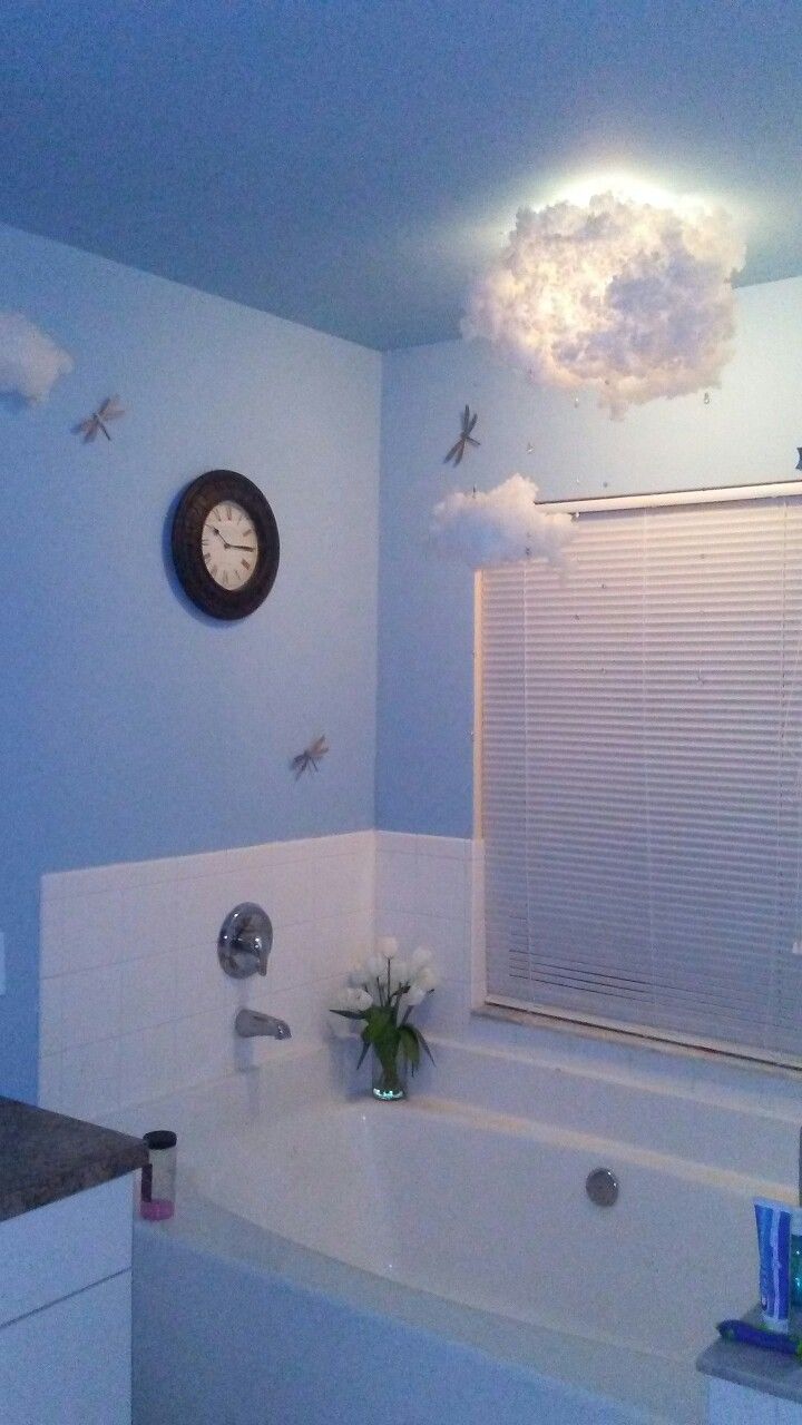 a bathroom with a clock on the wall above the bathtub and sink below it