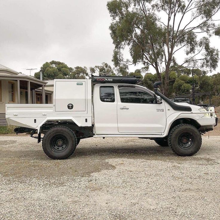 a white pick up truck parked in front of a house