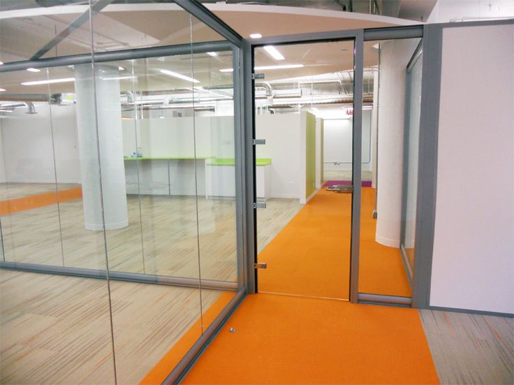 an empty office with glass walls and orange carpet