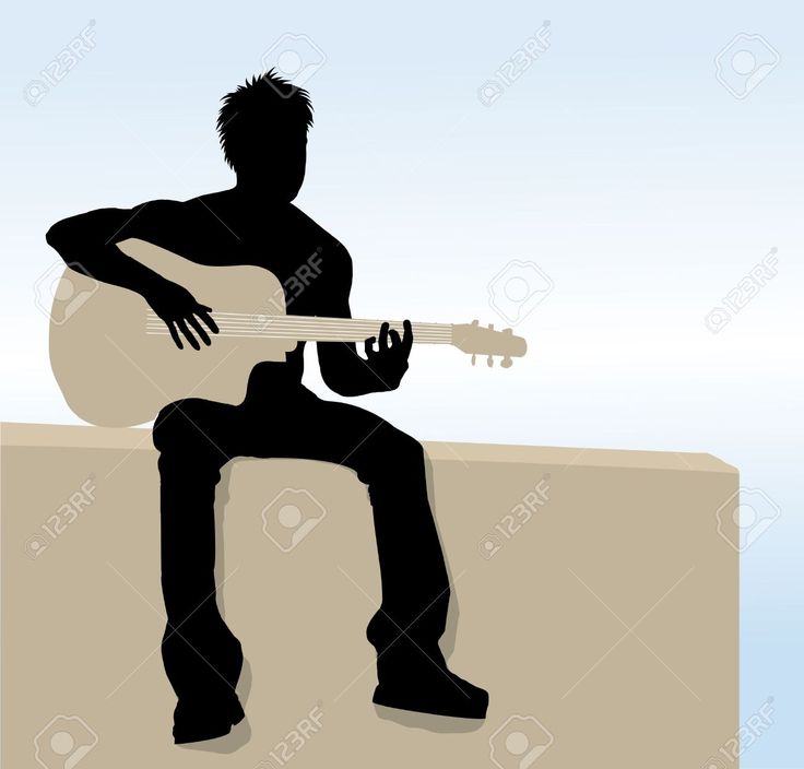 the silhouette of a man playing an acoustic guitar