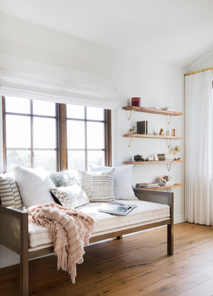 a living room filled with furniture and lots of window sill next to a wooden floor