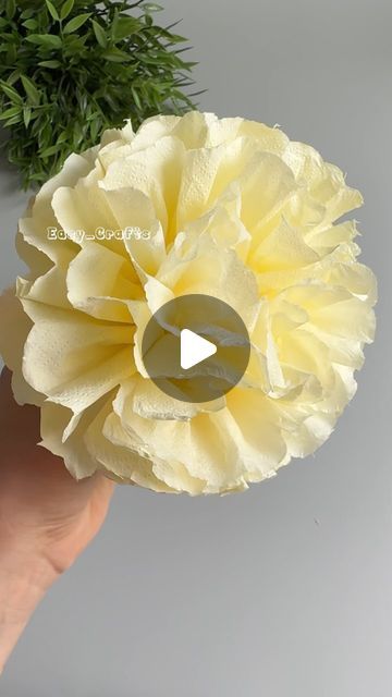 a person holding a yellow flower in their hand with the text, how to make paper flowers