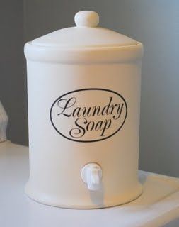 a white laundry soap dispenser sitting on top of a toilet