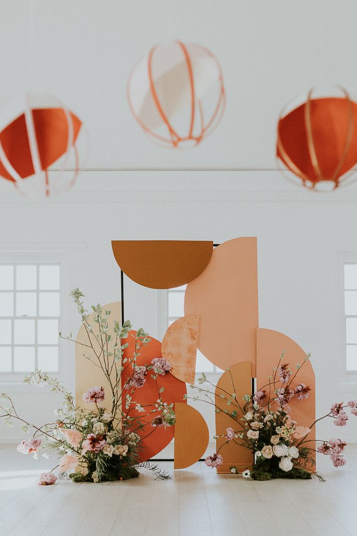 an arrangement of flowers in vases and paper lanterns