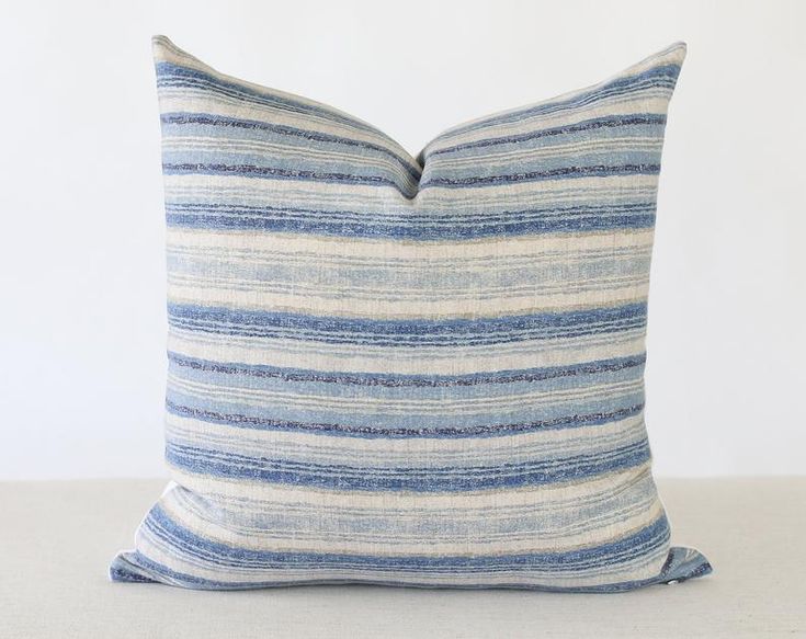 a blue and white striped pillow sitting on top of a table