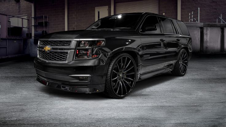 a black chevy suburban parked in a garage