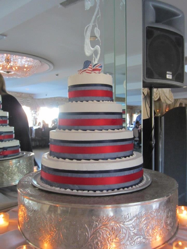 a three tiered cake with red, white and blue stripes on it sitting on top of a table