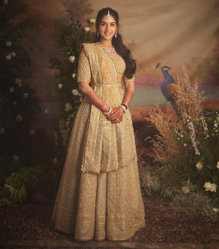 a woman standing in front of a painting wearing a yellow dress and headpieces