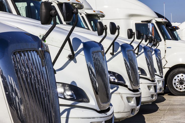 a row of semi trucks parked next to each other