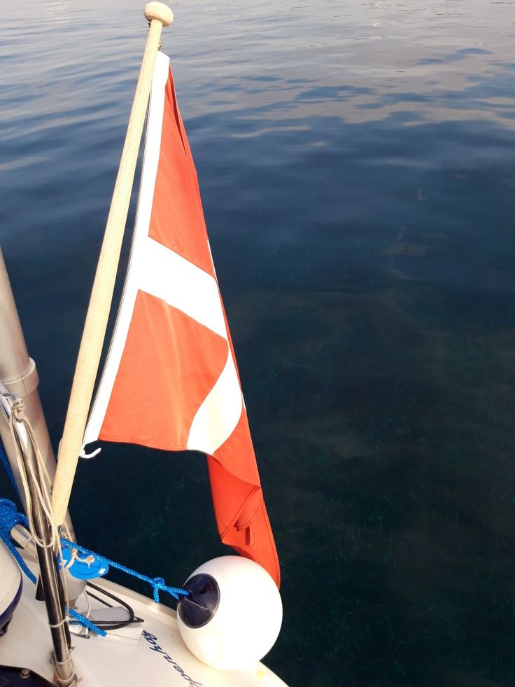 an orange and white flag on the side of a boat