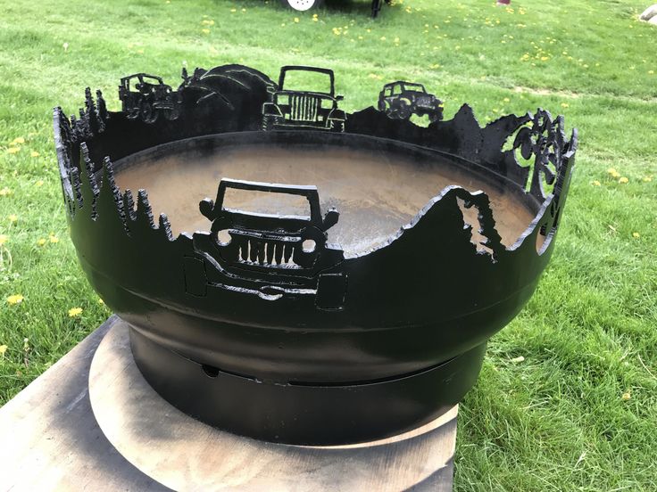 a large black grill sitting on top of a lush green field