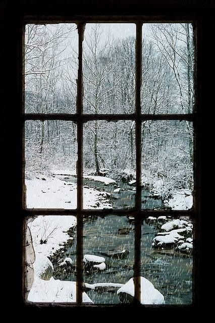 an open window with snow on the ground and trees in the background, looking out at a stream