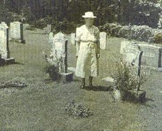 an old black and white photo of a woman standing in front of graves