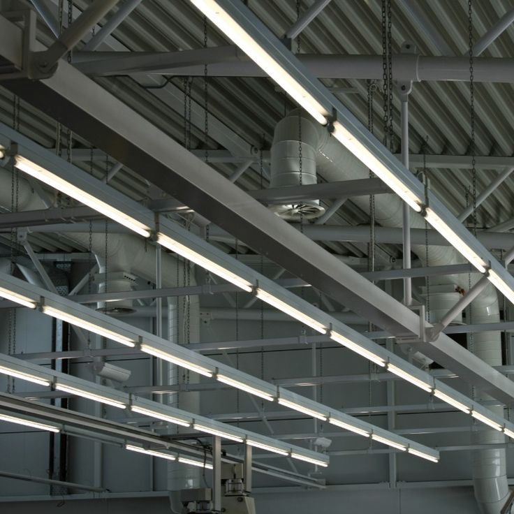 the lights are hanging from the ceiling in an industrial building with pipes and piping