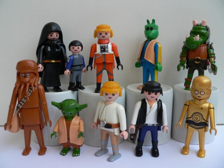 a group of star wars action figures sitting on top of a white table next to each other