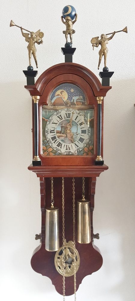 an old clock with bells and angels on it