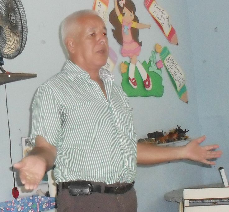 an older man standing in front of a fan and holding his hands out to the side