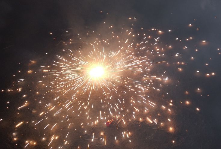 fireworks are lit up in the night sky with bright yellow and red lights on them