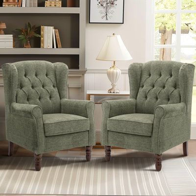 two green chairs sitting next to each other in a living room