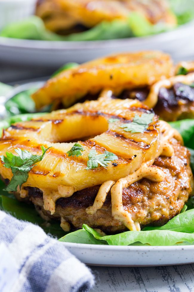 two plates filled with meat and pineapples on top of green lettuce