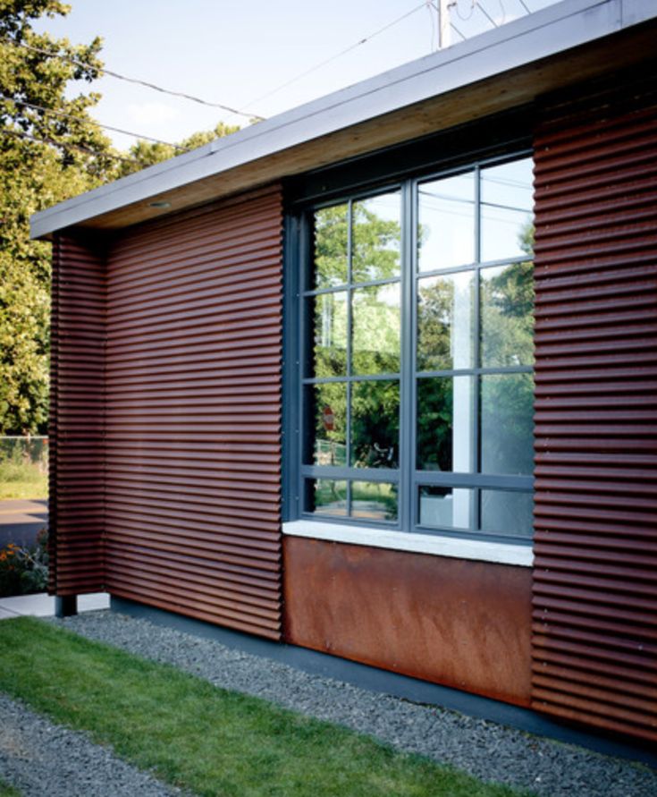 a house that is made out of wood and has a large window on the side