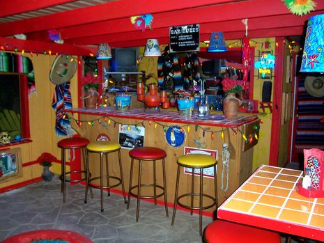 a brightly colored bar with yellow stools and red counter top, decorated with decorations