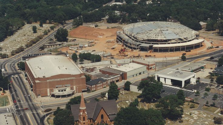 an aerial view of a large building under construction in the middle of trees and buildings