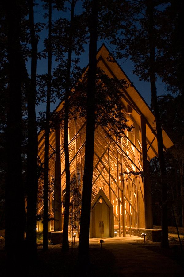 a church lit up at night in the woods