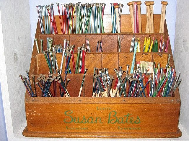 a wooden box filled with lots of different colored umbrellas in it's holder