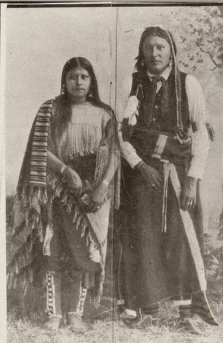 an old black and white photo of two native american people standing next to each other