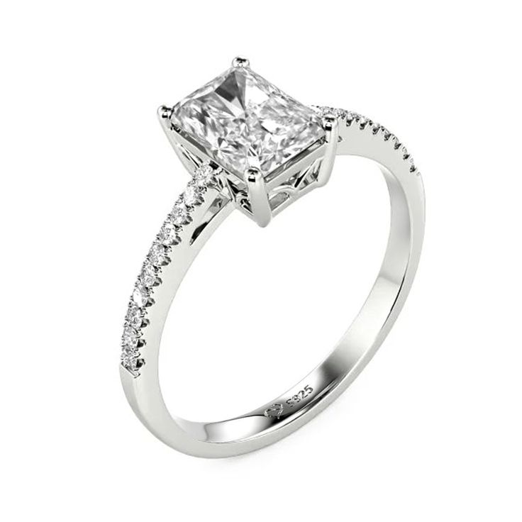 Elegant and elaborate. As the idealist type to enhance her incredible charm, this ring is the best option to accentuate the dazzling glamour of the emerald-cut center stone. Adorned with the shimmering stones pave shank, this ring will make a striking impression on your perfect wedding.Carat Weight: 1.55 ctStone Size: 5*7 mmStone Type: Jeulia® StoneNumber of Stones: 1 Stone Color: Diamond WhiteStone Shape: RadiantCarat Weight: 0.268 ctStone Size: 1.1,1.3 mmStone Type: Jeulia® StoneNumber of Ston Elegant Rectangular Diamond Ring With Accent Stones, Rectangular Rings With Pave Setting For Anniversary, Elegant Rectangular Emerald Ring With Prong Setting, Radiant Cut Emerald Ring In Diamond White, Elegant Rectangular Emerald Ring With Center Stone, Dazzling Square-cut Diamond Ring, Elegant Rectangular Rings With Accent Stones, Elegant Promise Jewelry With Side Stones, Elegant Side Stones Jewelry For Promise