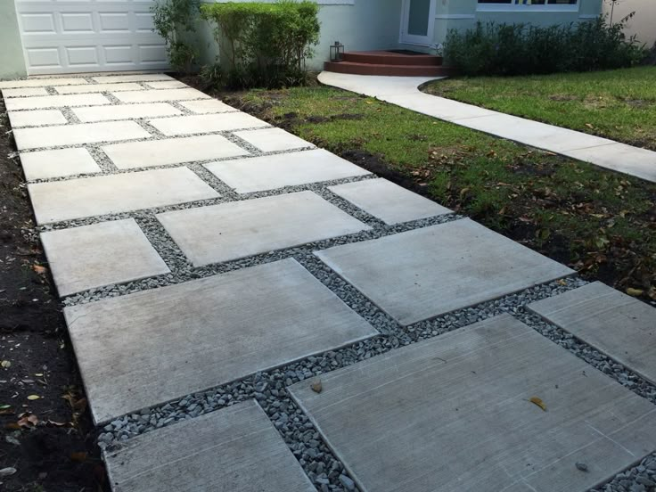 a walkway made out of stones in front of a house