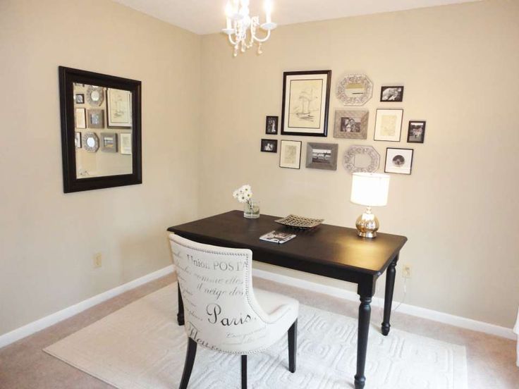 a black desk with white chairs and pictures on the wall