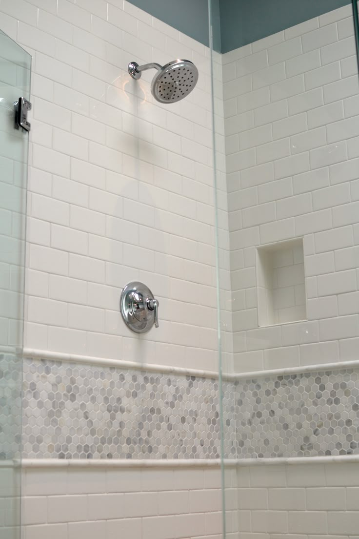 the shower head is mounted on the wall next to the bathtub faucet