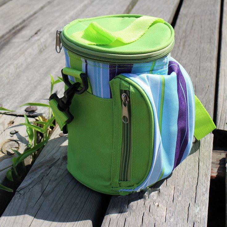 a green lunch bag sitting on top of a wooden bench