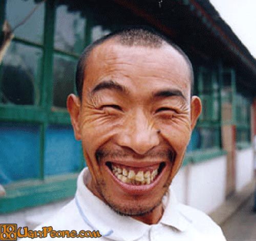 a smiling man with his mouth open in front of a group of people on the sidewalk