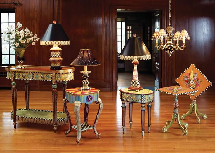 three lamps and two end tables on the floor in front of a mirror with an ornate design