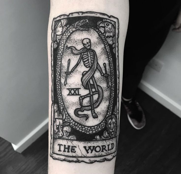 a tattoo on the arm of a person with a skeleton holding a cross in it