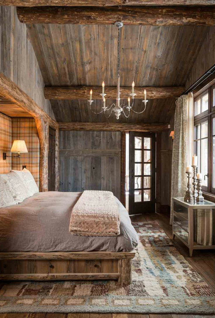 a bedroom with wooden walls and ceilinging has a chandelier