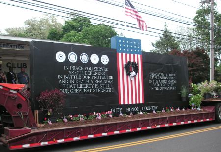 the back of a truck with an american flag on it's flatbed trailer