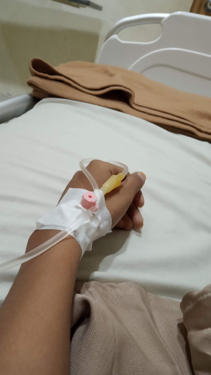 a person in a hospital bed with an iv tube wrapped around their arm and hand