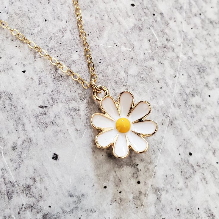 Step into a world of playful elegance with this Gold Dainty Daisy Charm Necklace. This adorable piece of jewelry is here to add a touch of enchantment to your everyday style. It's like capturing a piece of nature's cheerfulness and wearing it as a symbol of your vibrant spirit. This necklace brings a lighthearted touch to any outfit, whether you're dressing up for a special occasion or adding a playful accent to your casual look. Its dainty design and shimmering gold finish effortlessly elevate Adjustable Nature-inspired Necklace For Gift, Nature-inspired Adjustable Jewelry Gift For Her, Nature-inspired Adjustable Jewelry As Gift For Her, Adjustable Nature-inspired Jewelry Gift For Her, Adjustable Nature-inspired Jewelry As Gift For Her, Nature-inspired Pendant Necklace As Gift For Her, Cute Gold Jewelry With Flower Charm, White Dainty Hypoallergenic Charm Necklace, Dainty White Hypoallergenic Charm Necklace