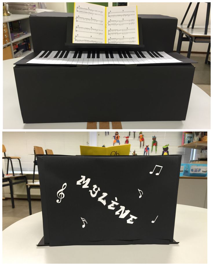 an open box with music notes on it and a piano keyboard in the back ground