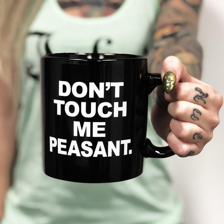 a woman holding a black coffee mug that says don't touch me peasant