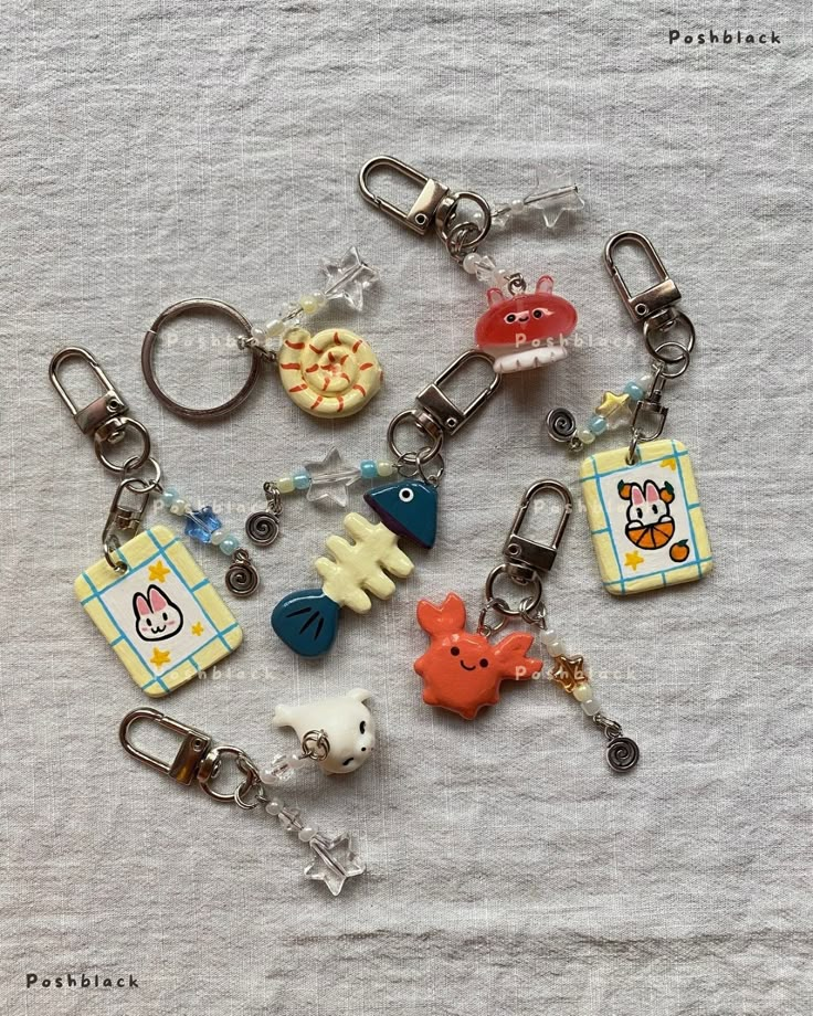 a bunch of keychains that are on top of a white sheet with various items