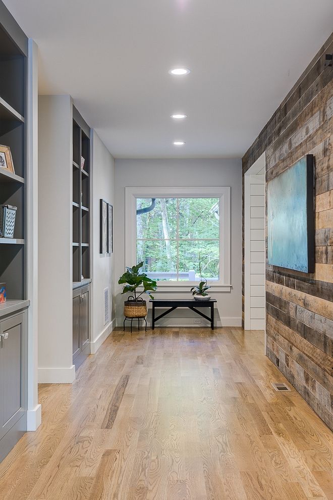 an empty living room with wood floors and built in bookshelves on the wall