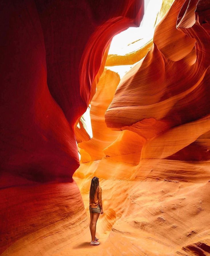 a woman is standing in the middle of a narrow slot at antelope canyon